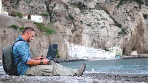 男人用笔记本电脑笔记本电脑看智能手机接电话在去国外旅行时找到信息交流n视频的预览图