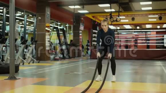运动妇女在健身房进行交叉健身运动时练习战绳运动视频的预览图