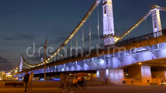人们穿着明亮的彩灯走在舒适的桥堤上视频的预览图