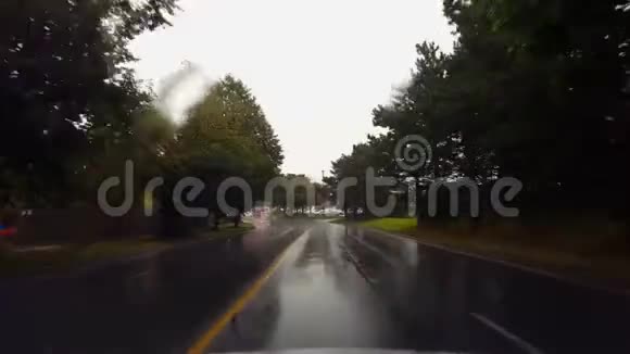 在夏日驾驶雨城街道俯瞰天空司机视角POV雨市湿路视频的预览图
