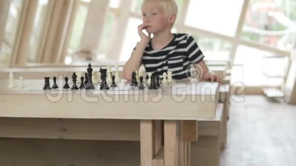 英俊的金发男孩在下棋视频的预览图