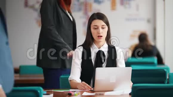 人们坐在办公室的桌子旁讨论他们的工作一个年轻的女人在报告视频的预览图