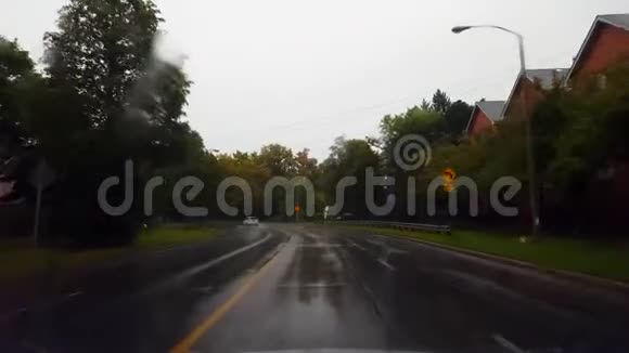 在夏日驾驶雨城街道俯瞰天空司机视角POV雨市湿路视频的预览图
