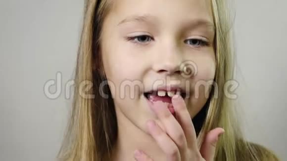 可爱的微笑女孩宝宝摇着手指奶方在室内白色背景年龄概念下的牙齿流失视频的预览图