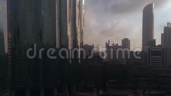 日落时分城市摩天大楼周围的云层时间推移阿布扎比天际线和世界贸易中心视频的预览图