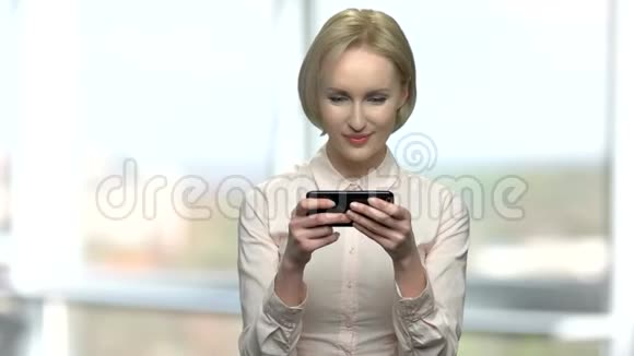 优雅的女人玩手机游戏视频的预览图