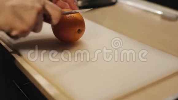 在白色的切割板上剪一个鲜橙色的男性手的特写视频的预览图