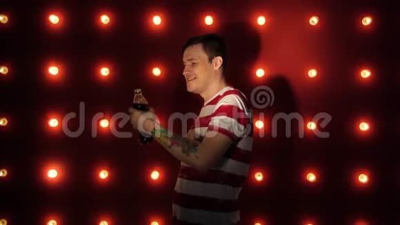 一个有纹身的男人喝一杯清爽的饮料年轻的白种人男性从瓶子里喝一杯视频的预览图