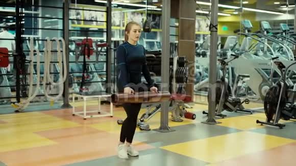 强壮的女运动员在健身房里用健身管慢动作蹲着视频的预览图