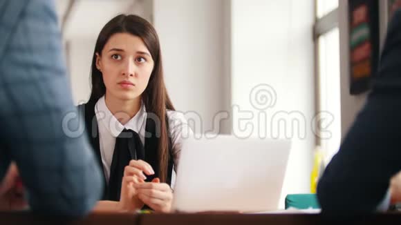一个年轻的女人报告她的工作听着她报告上的评论继续她的笔记本电脑视频的预览图