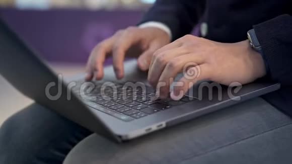 用智能手表在灰色笔记本电脑上打字近距离拍摄男性手视频的预览图