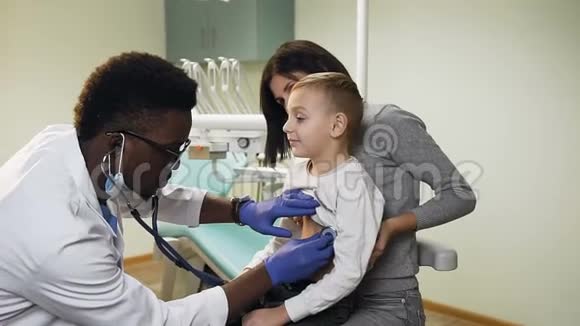 非洲男医生在办公室用听诊器检查小男孩的心率视频的预览图