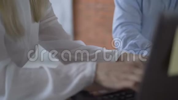 女人手在键盘上积极打字女人把笔记本电脑交给伴侣批准视频的预览图