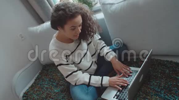 漂亮的年轻女人在家里用笔记本电脑视频的预览图