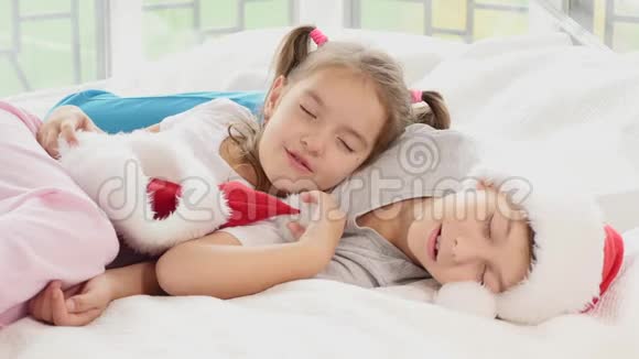 两个精疲力竭的孩子正在睡觉新年聚会后他们甜蜜地拥抱着视频的预览图