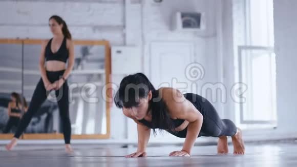 运动型美女在交叉健身馆的地板上做俯卧撑女运动员在健身房锻炼交叉装备视频的预览图