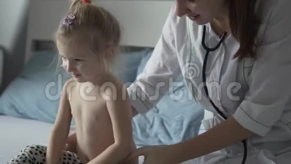 医院里的一位医生正在听一个有脚趾甲的小女孩说话视频的预览图