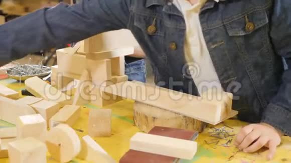 孩子们在工艺车间玩耍可爱的小男孩在玩木头碎片特写镜头小子楼4k视频的预览图