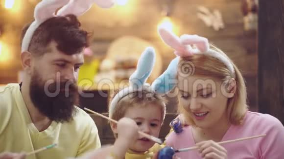 画复活节彩蛋的家庭的特写母亲父亲和儿子正在画鸡蛋幸福的家庭正在准备视频的预览图