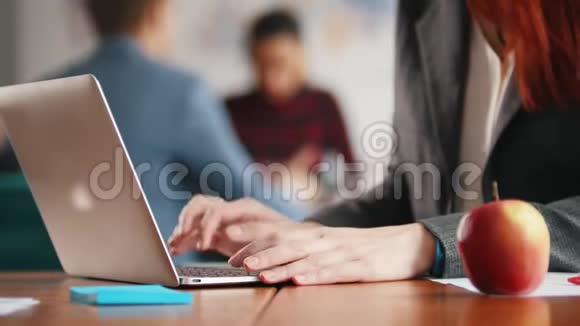 一个女人的手在笔记本电脑上贴胶带手里拿着一个苹果视频的预览图