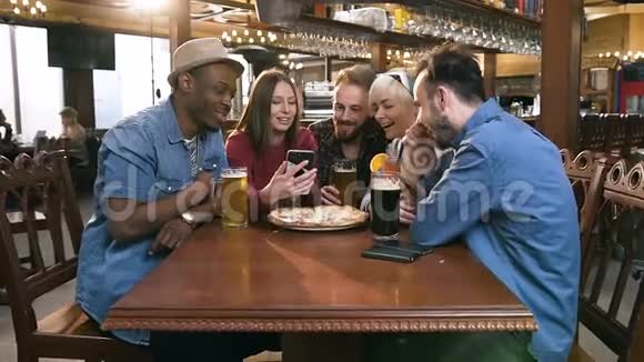 群快乐的hipster朋友一起看视频拍照在智能手机上一起在酒吧酒吧视频的预览图