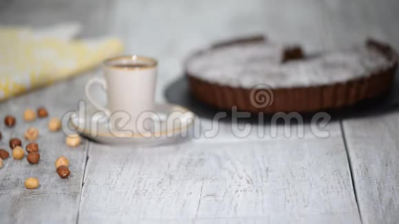 白色木质背景上带有榛子的自制巧克力馅饼视频的预览图