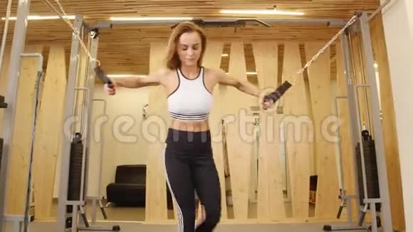 运动员微笑的女人在健身房健身准备手操视频的预览图