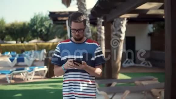 商人正在智能手机上阅读电子邮件在酒店度假时散步视频的预览图