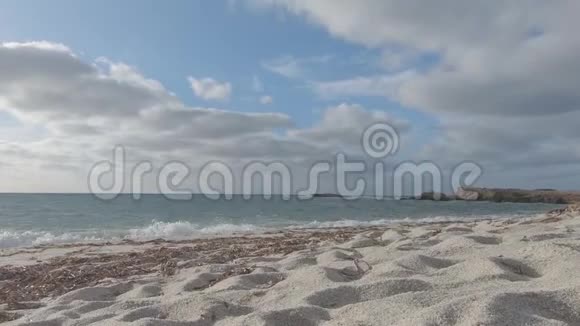 背景为海浪和多云天空的白色石英沙粒的背光视角视频的预览图