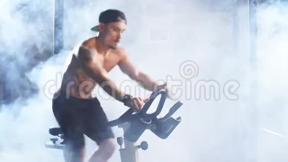 心脏手术无衫运动男子在健身房骑自行车训练视频的预览图
