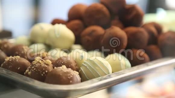 白色棕色的美味糖果洒在柜台金属板特写上视频的预览图