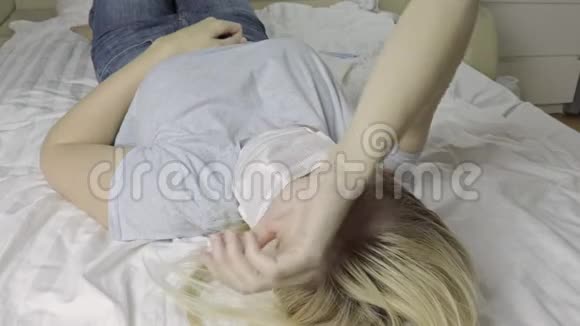 躺在床上戴着医用口罩的患病妇女视频的预览图