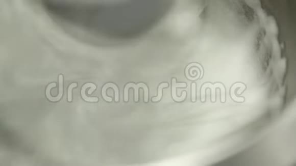 混合机将奶油牛奶泡沫在金属平板特写中旋转视频的预览图