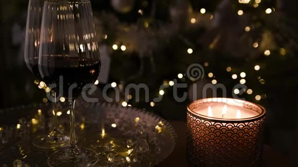 背景中的圣诞树模糊了灯光前景中的葡萄酒视频的预览图
