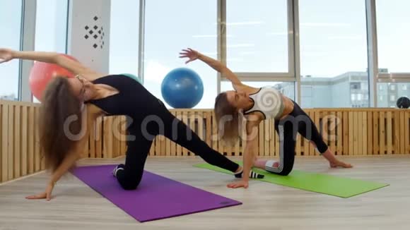 年轻女性在健身房做瑜伽弯到一边视频的预览图