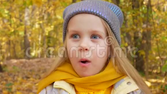 秋天小可爱的女孩在公园吃苹果微笑着视频的预览图