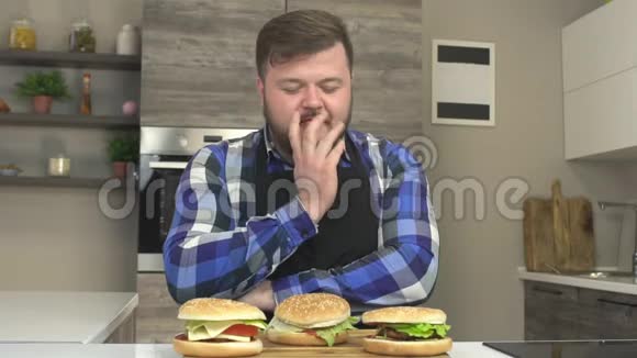 一个长着胡须的胖子舔着牙齿想吃芝士汉堡快乐渴望食物超重慢吞吞视频的预览图