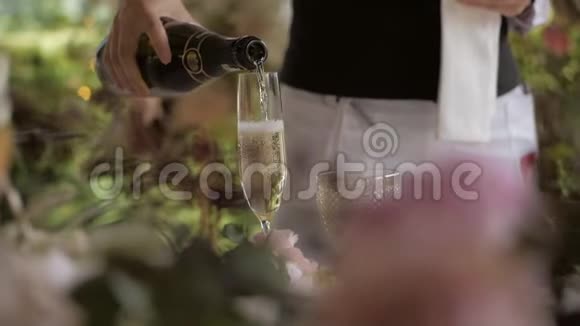 服务员把香槟从瓶子里倒进玻璃杯里视频的预览图