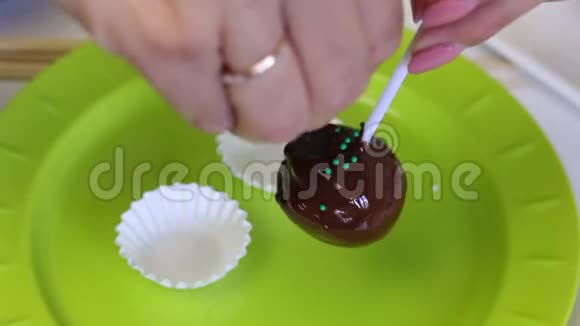 一个女人用装饰装饰装饰一个蛋糕流行蛋糕空白敷料粘在融化的巧克力上视频的预览图