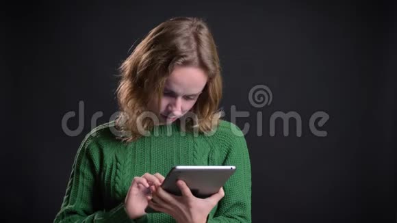 成人白种人女性在笔记本电脑上的特写镜头在微笑的同时将蓝色屏幕显示在镜头中视频的预览图