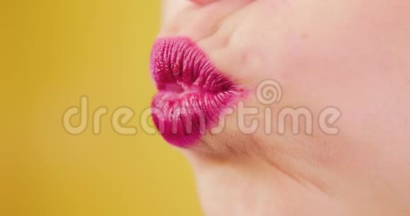 特写粉嫩透亮的女唇女孩亲吻和微笑的黄色背景在工作室孤立爱空气视频的预览图