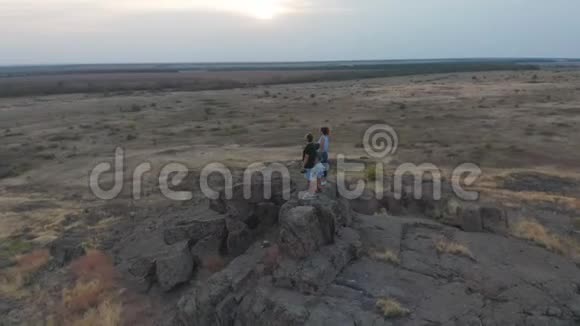 空中观景一家人站在山上母亲父亲和儿子去山里远足日落视频的预览图