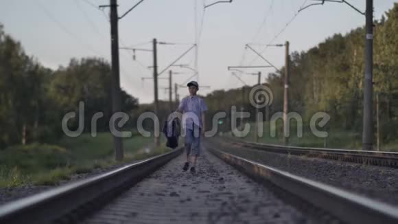 带旅行包的有趣男孩坐火车去户外视频的预览图