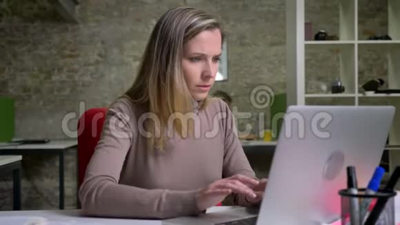 情绪激动的女办公室职员在笔记本电脑上打字并因失败而感到沮丧视频的预览图