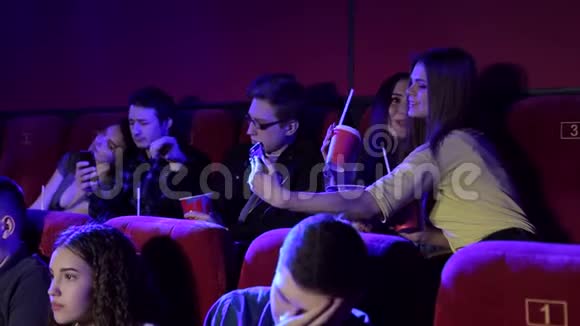 一群快乐的青少年在后排的电影院里自拍视频的预览图