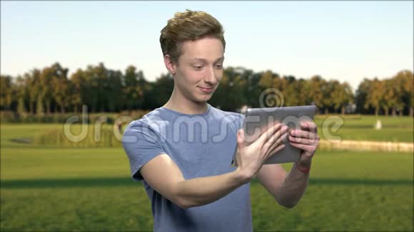 吸引人的青少年使用电脑平板电脑户外视频的预览图