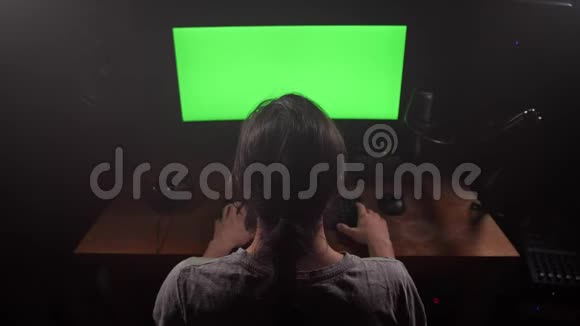 一个留着长发的男人在键盘上打印文字他的显示器上有一个绿色的屏幕4K慢慢视频的预览图