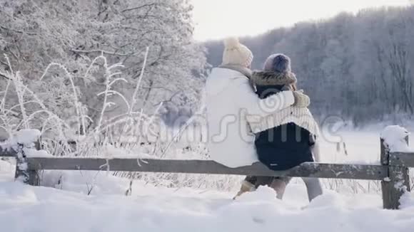 妈妈和女儿拥抱着欣赏冬天的风景视频的预览图