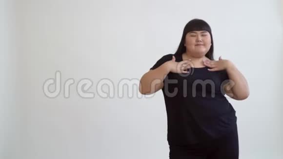 精力充沛的亚洲女孩快乐的脂肪舞蹈缓慢的动作在白色的背景视频的预览图