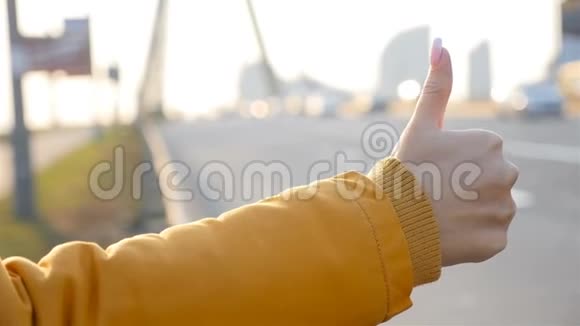 女性手的特写拇指向上汽车的运动慢动作回到镜头前秋天的天气视频的预览图